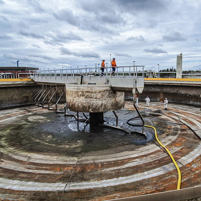 A wastewater clarifier being cleaned by PMA team members